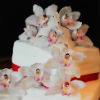 Asymmetrical three-tiered pink-and-white cake with elaborate flower detailing